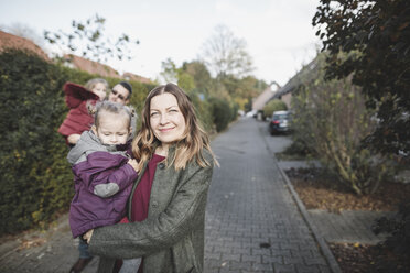 Porträt einer Familie auf einem Weg in einem Wohngebiet - KMKF00837