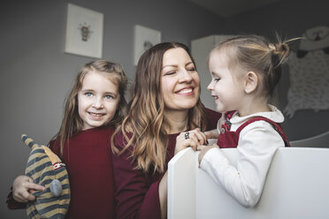 Glückliche Mutter mit zwei Mädchen zu Hause - KMKF00848