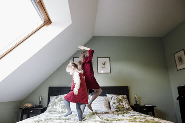 Zwei Mädchen hüpfen auf dem Bett - KMKF00849