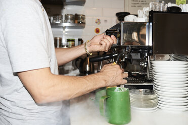 Nahaufnahme eines Barista bei der Kaffeezubereitung - IGGF01154