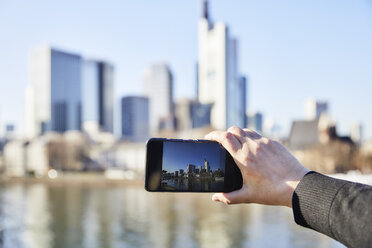 Deutschland, Frankfurt, Hand fotografiert Finanzviertel mit Mobiltelefon - FMKF05541