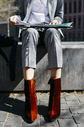 Junge Geschäftsfrau mit roten Schuhen, auf einer Bank in der Stadt sitzend, am Laptop arbeitend, tiefer Ausschnitt - JRFF03070