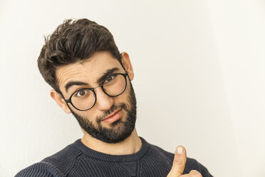 Porträt eines zweifelnden jungen Mannes mit Bart und Brille - TCF06078