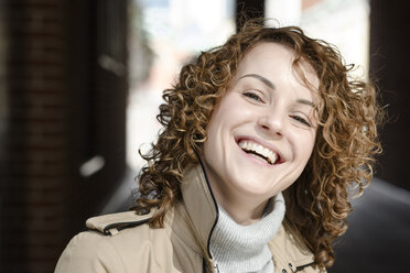 Porträt einer lachenden Frau mit lockigem Haar - EYAF00149