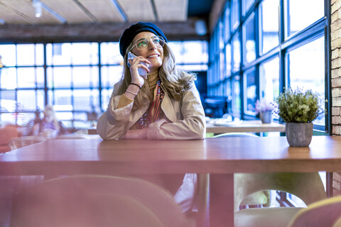 Smiling woman on cell phone in a cafe stock photo