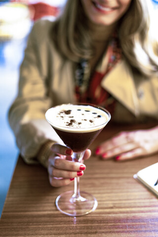 Nahaufnahme einer Frau mit einem Kaffeecocktail in einem Café, lizenzfreies Stockfoto