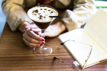 Nahaufnahme einer Frau mit einem Kaffeecocktail in einem Café - ERRF01071