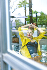 Frau hinter Fensterscheibe in einem Café - ERRF01099