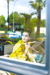 Frau hinter Fensterscheibe in einem Café - ERRF01100