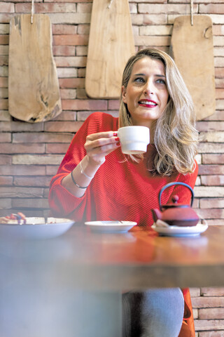 Smiling woman drinking tea in a cafe stock photo