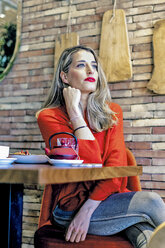 Woman sitting at table in a cafe - ERRF01143