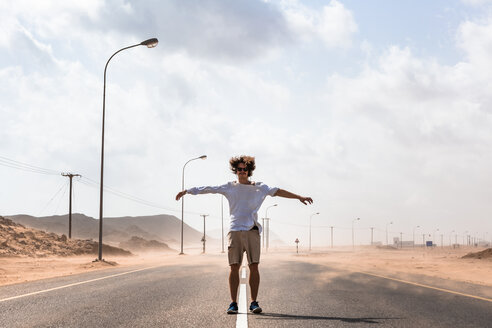 Sultanate Of Oman, Ras al Hadd, Desert road, Man standing in a sand storm - WVF01129