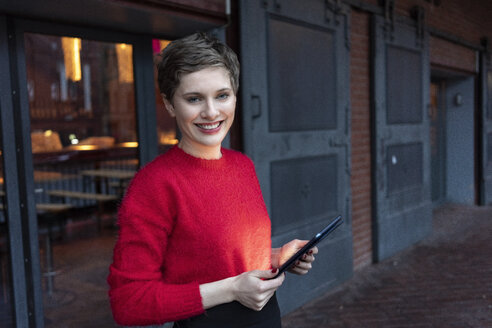 Germany, Berlin, portrait of confident businesswoman with digital tablet outdoors - TAMF01277