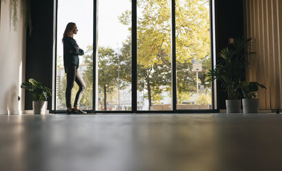 Businesswoman looking out of window - GUSF01853