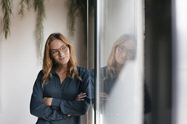 Businesswoman looking out of window - GUSF01854