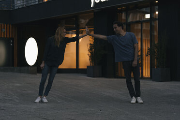 Young couple supporting each other in the city at night - GUSF01894