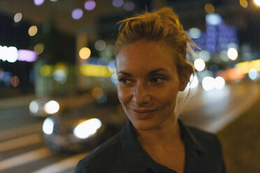 Porträt einer jungen Frau in der Stadt bei Nacht - GUSF01908