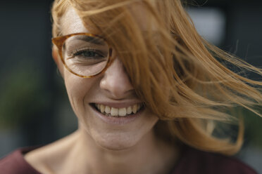 Portrait of happy young woman with glasses and windswept hair - GUSF01933