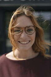 Porträt einer glücklichen jungen Frau mit Brille und zerzaustem Haar - GUSF01934