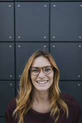 Porträt einer lächelnden jungen Frau mit Brille - GUSF01946