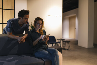 Young man and woman using tablet on couch - GUSF01949