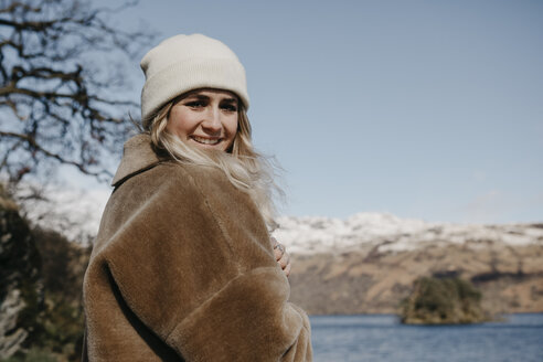UK, Schottland, Porträt einer lächelnden jungen Frau am Loch Lomond - LHPF00536