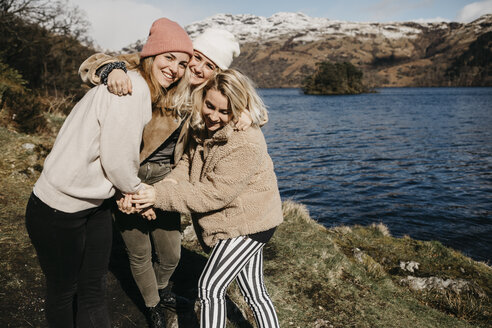 UK, Schottland, glückliche Freundinnen umarmen sich am Loch Lomond - LHPF00538