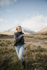 Vereinigtes Königreich, Schottland, Loch Lomond and the Trossachs National Park, glückliche junge Frau beim Laufen in ländlicher Landschaft - LHPF00562