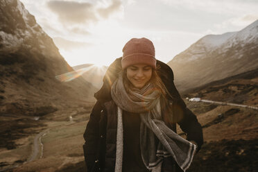 Großbritannien, Schottland, Highlands, lächelnde junge Frau in ländlicher Landschaft - LHPF00579