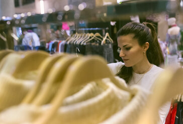 Frau kauft Kleidung in einer Vintage-Boutique - MGOF04002