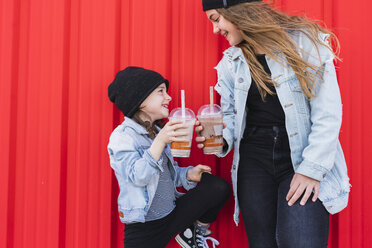 Teenage girl and little sister toasting with drinks - ERRF01147