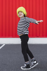 Kleines Mädchen mit gestreiftem Hemd und gelber Mütze beim Balancieren - ERRF01172