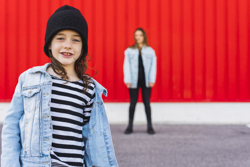 Portrait of little girl with older sister standing in the background - ERRF01175