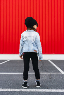 Rückenansicht eines kleinen Mädchens mit Jeansjacke, schwarzer Mütze und übergroßer Sonnenbrille - ERRF01184