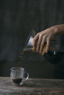 Nahaufnahme eines Mannes, der gefilterten Kaffee in ein Glas gießt - ALBF00842