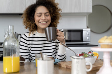 Woman sitting in kitchen, having breakfast - FMOF00589