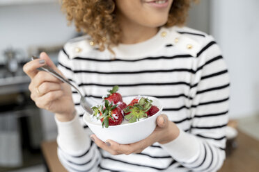 Woman eating strawberries at home - FMOF00592