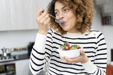 Frau isst Erdbeeren zu Hause - FMOF00593
