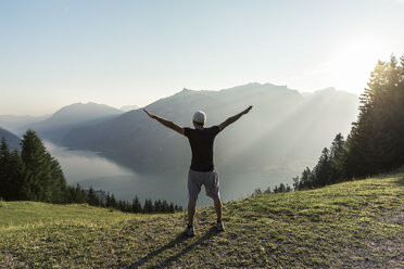 Austria, Tyrol, Man standing in the mountains looking over lake Achsensee - WFF00082