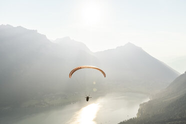 Austria, Tyrol, Paraglider over lake Achensee in the early morning - WFF00084