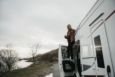 UK, Schottland, Highland, glückliche junge Frau in einem Wohnmobil - LHPF00610