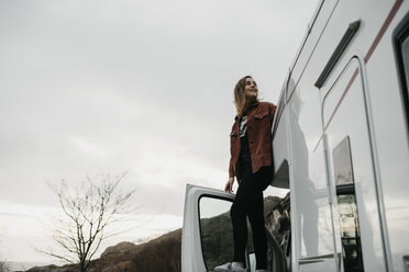 UK, Scotland, Highland, happy young woman at a camper van - LHPF00611