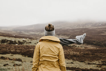 Großbritannien, Schottland, Isle of Skye, Rückansicht einer jungen Frau in ländlicher Landschaft - LHPF00618