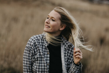 UK, Scotland, Highland, portrait of smiling young woman in rural landscape - LHPF00624