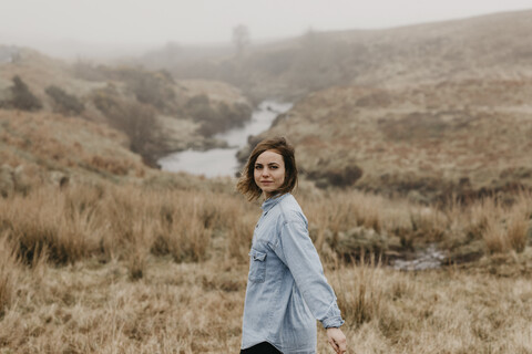 UK, Schottland, Isle of Skye, Porträt einer jungen Frau in ländlicher Umgebung, lizenzfreies Stockfoto