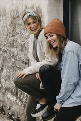 UK, Schottland, zwei lachende junge Frauen vor einem Gebäude - LHPF00633