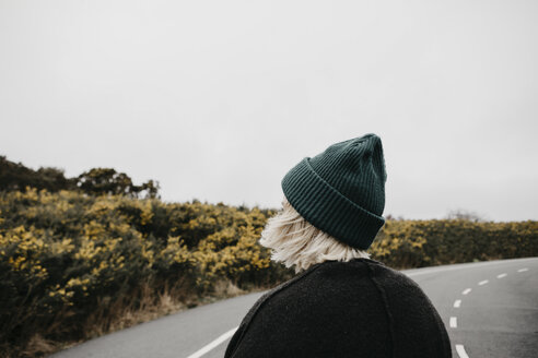 UK, Scotland, Isle of Skye, rear view of young woman on country road - LHPF00637