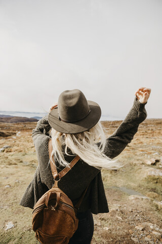 UK, Schottland, Highland, Applecross, Rückansicht einer jungen Frau in ländlicher Umgebung, lizenzfreies Stockfoto