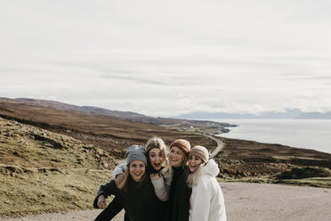 UK, Schottland, Highland, glückliche Freundinnen auf einer Straße an der Küste - LHPF00652