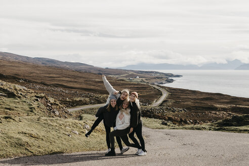 UK, Schottland, Highland, glückliche Freundinnen auf einer Straße an der Küste - LHPF00653